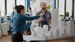 team coworkers analyzing maquette building model plan construction tablet architectural people working together designing urban strategy real estate development Ally Bohanan Real Estate | Luxury Real Estate in Gastonia, NC